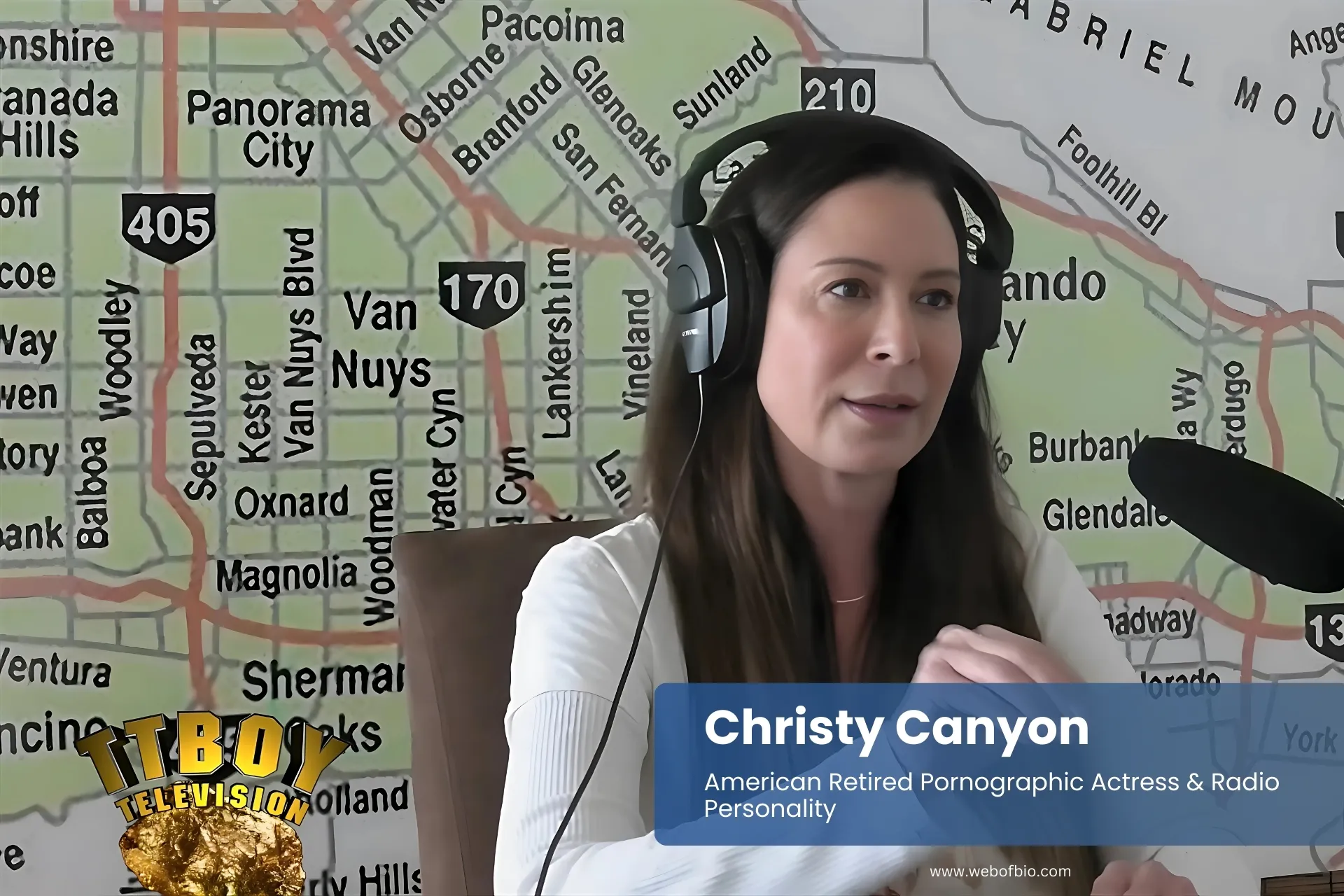 Christy Canyon with headphones, speaking into microphone.
