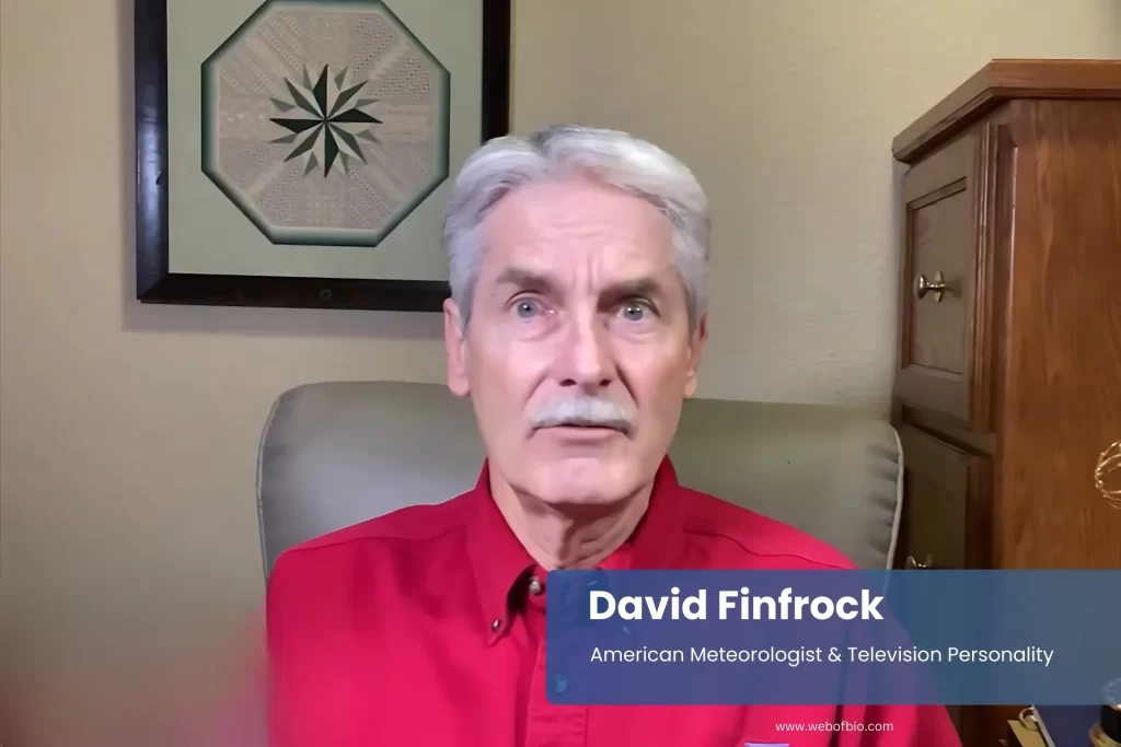 David Finfrock pink shirt, seated at desk.