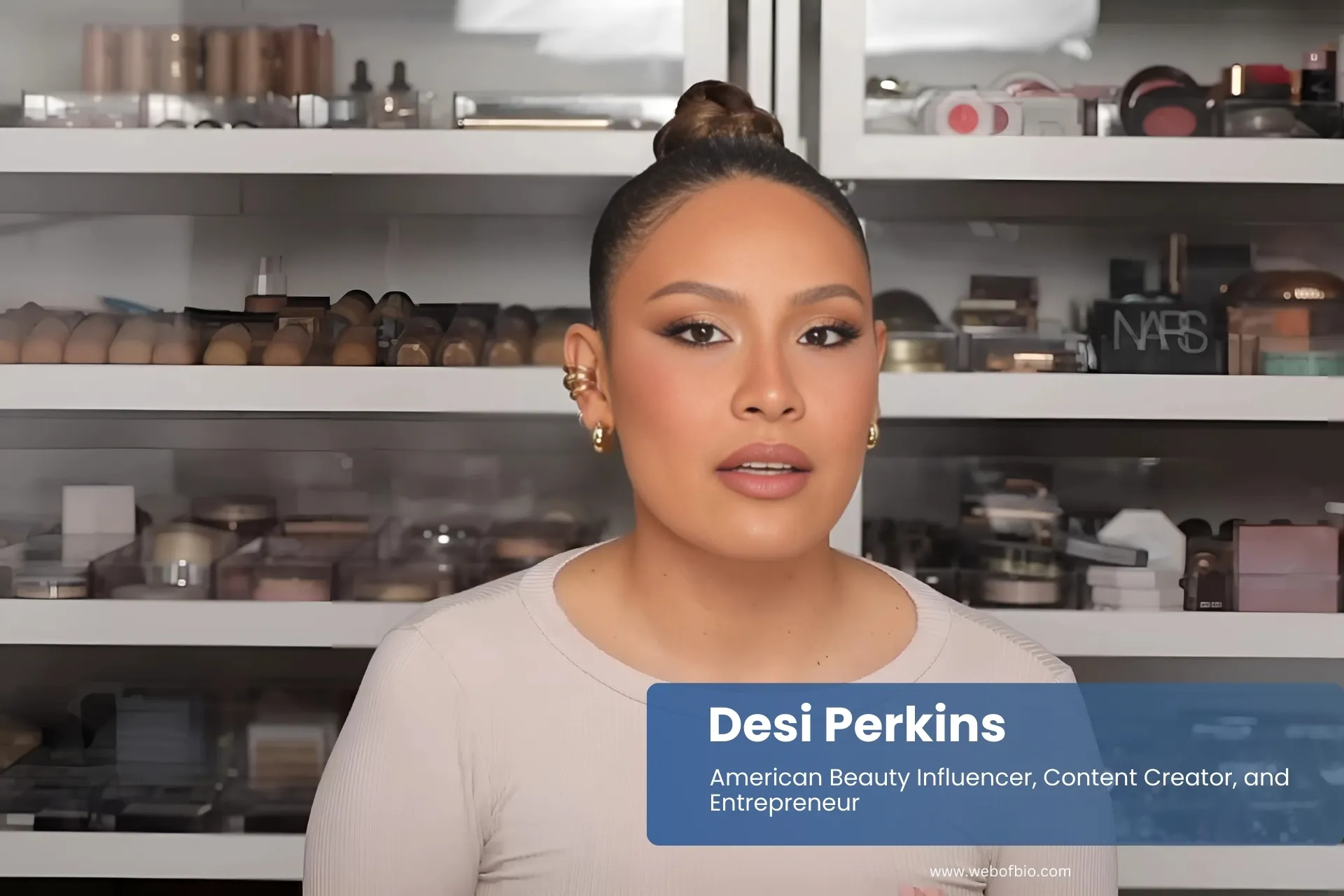 Desi Perkins by makeup shelf.