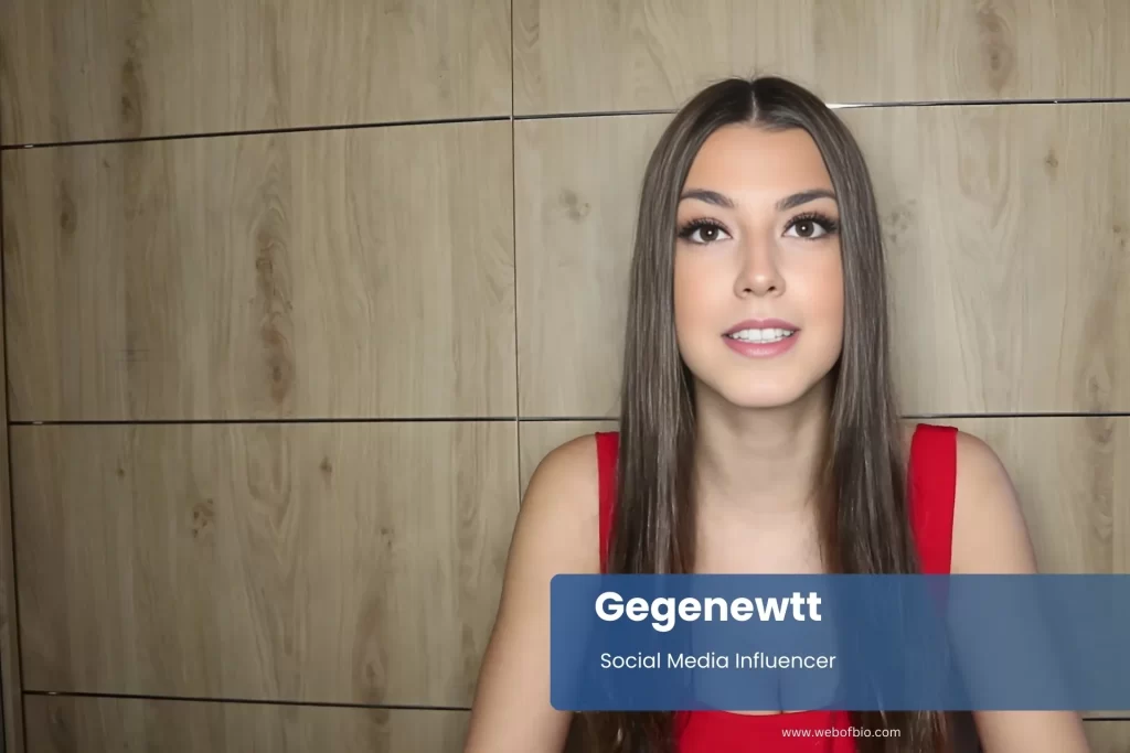Gegenewtt vibrant red dress looking at camera.