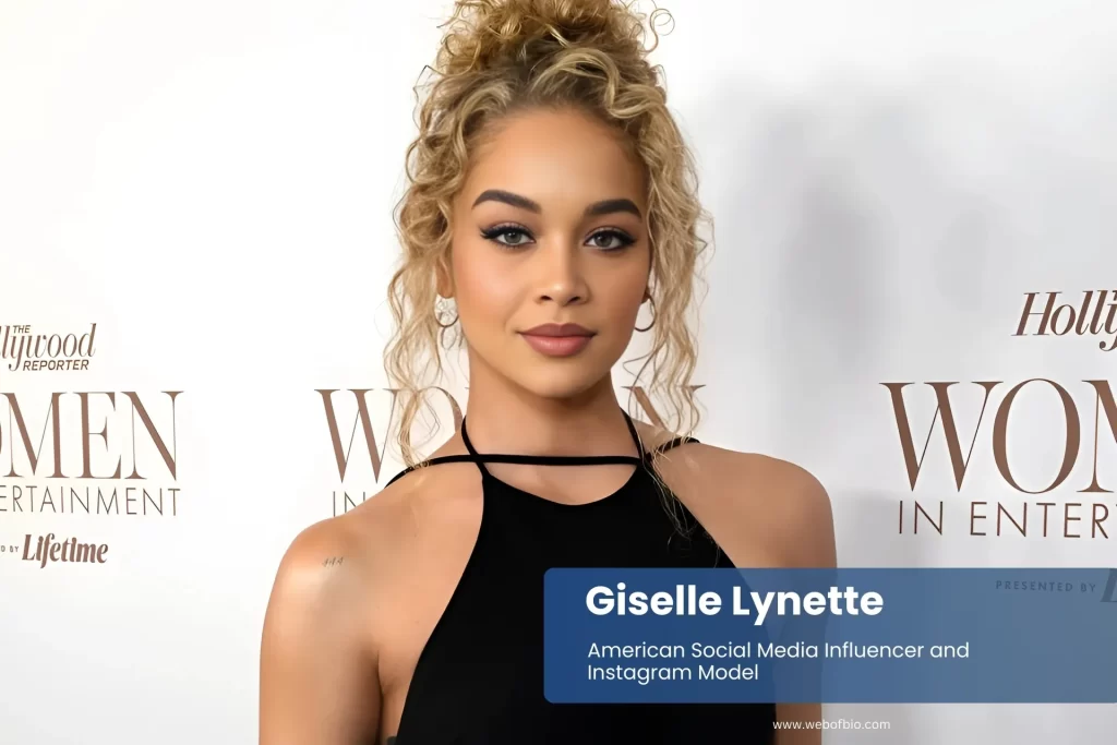 Giselle Lynette black dress at formal event, posing.