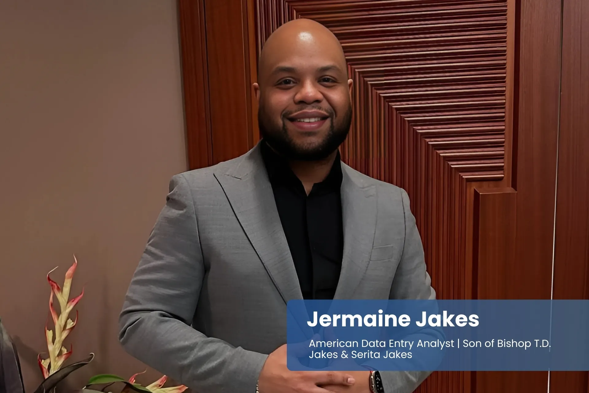 Jermaine Jakes in suit, standing by closed door.