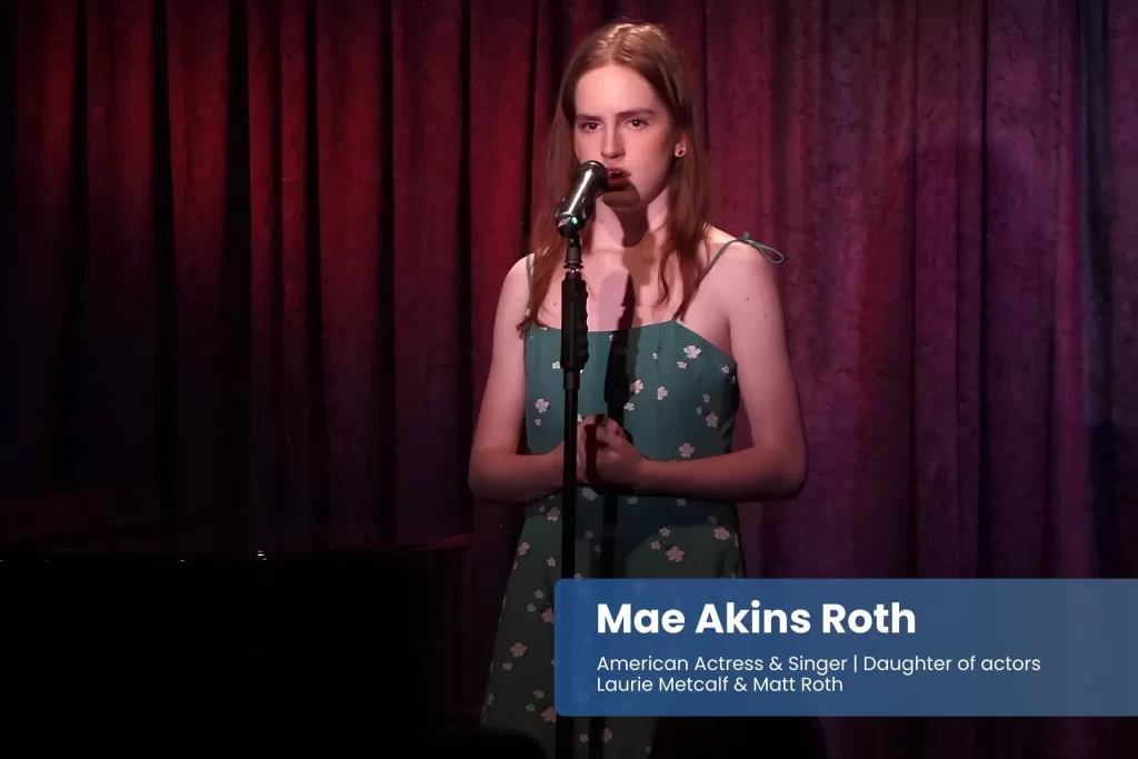Mae Akins Roth singing into microphone in dress.