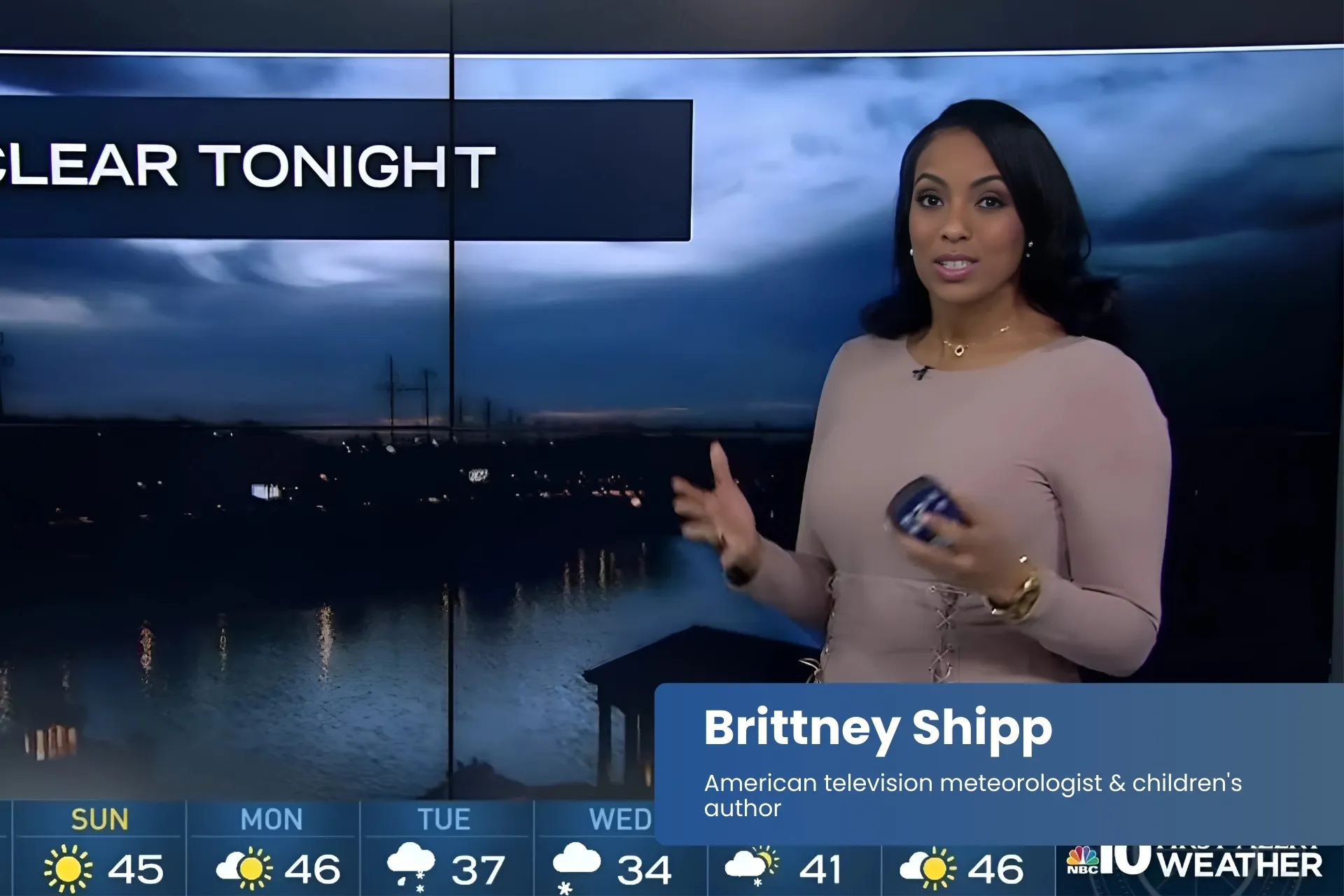 Brittney Shipp in front of TV screen, delivering news