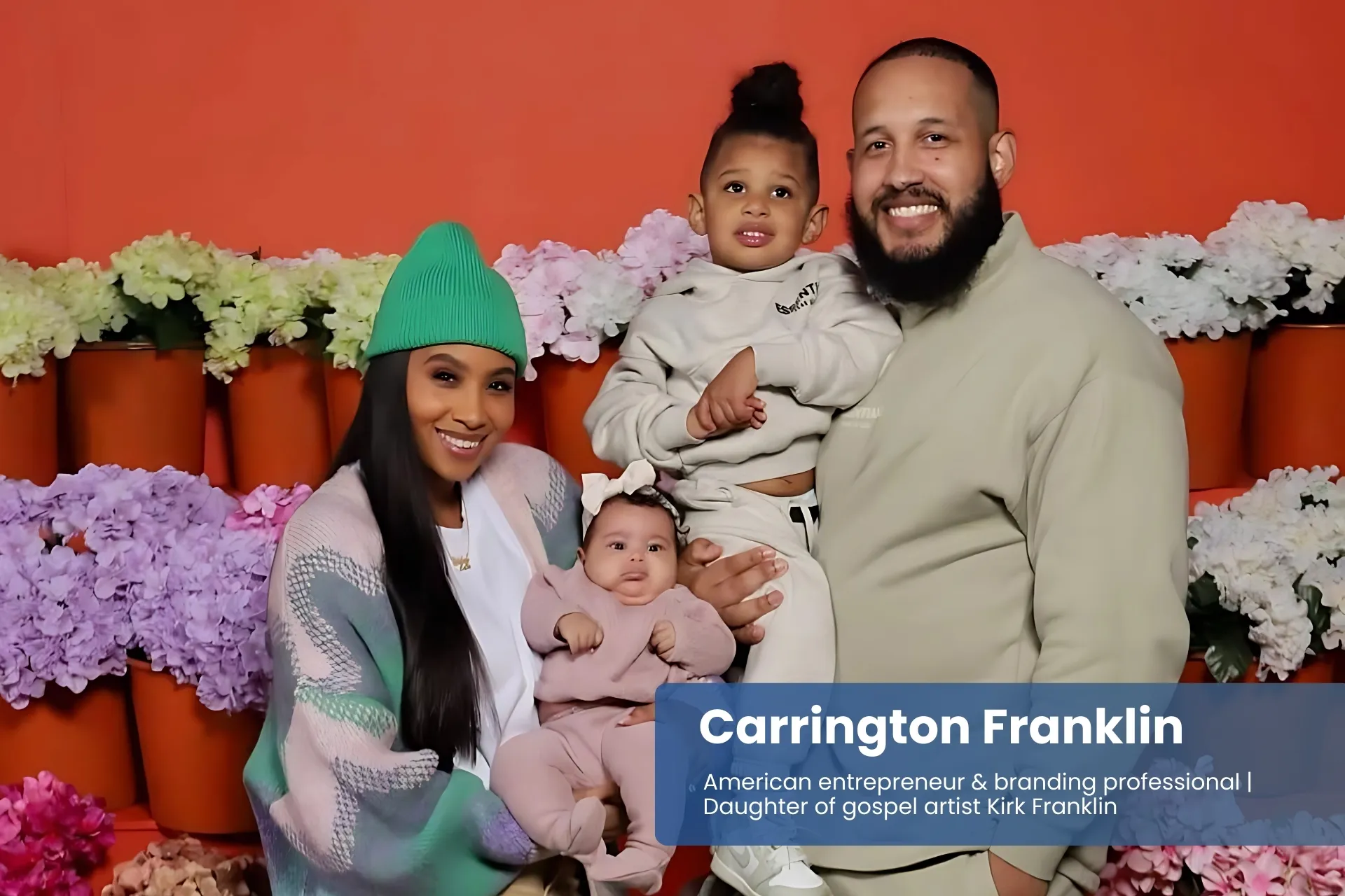 Carrington Franklin and husband with children by flower wall