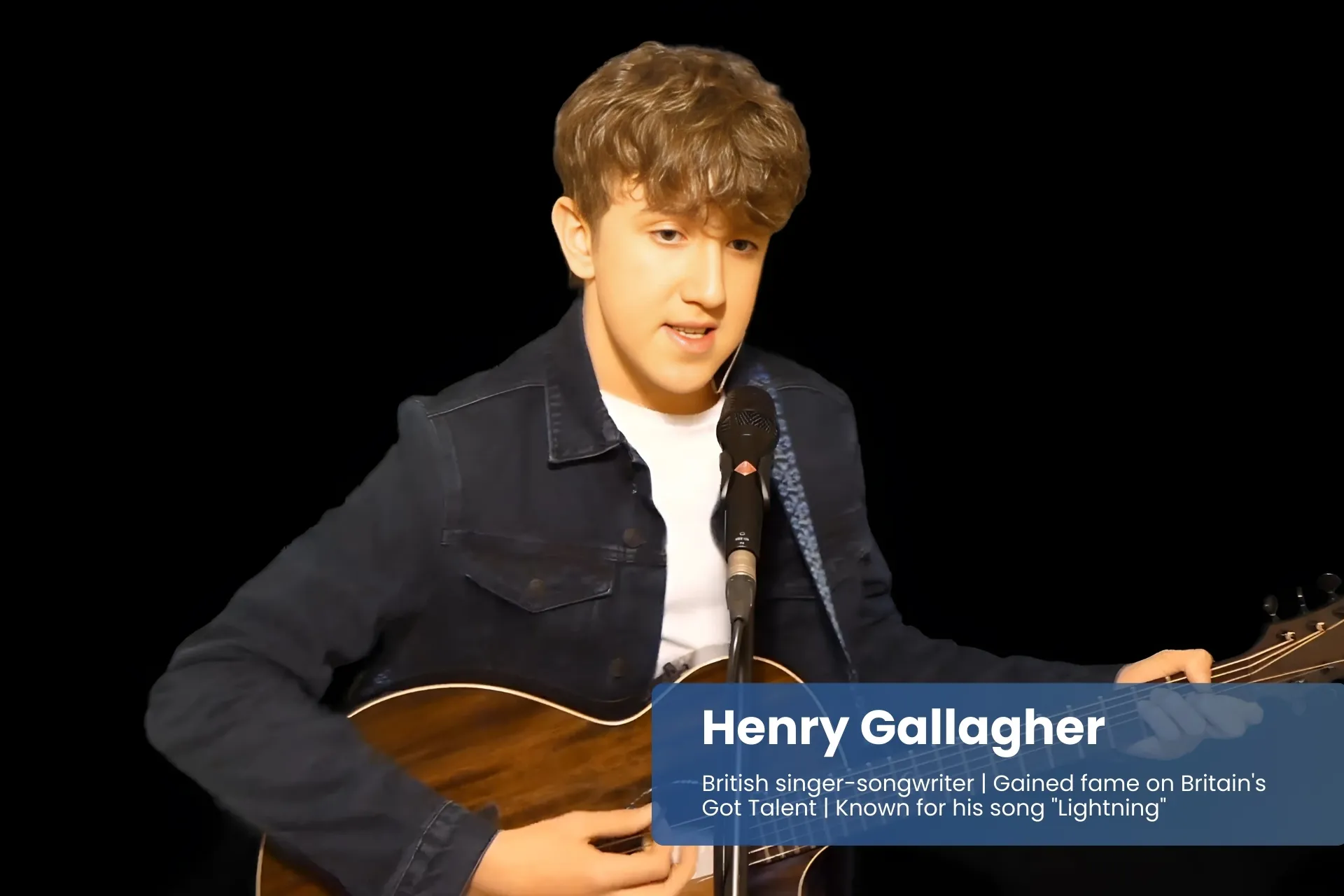 Henry Gallagher playing acoustic guitar